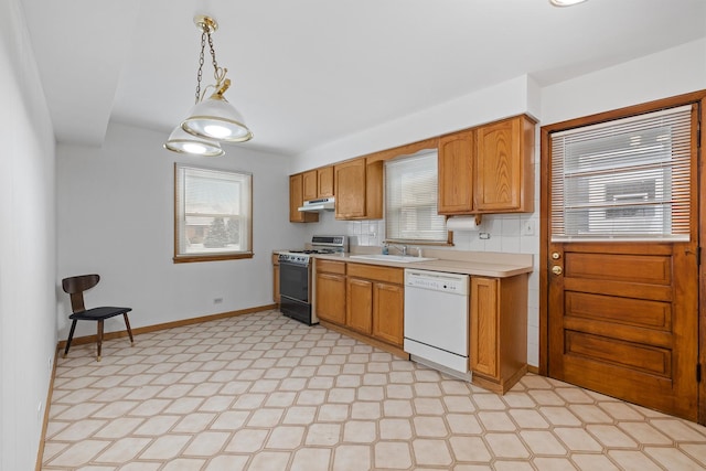 kitchen with tasteful backsplash, range with gas cooktop, white dishwasher, sink, and decorative light fixtures