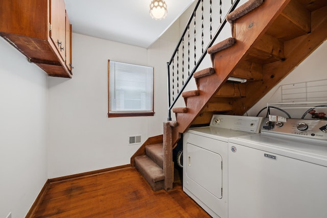 clothes washing area featuring cabinets, independent washer and dryer, and wood-type flooring