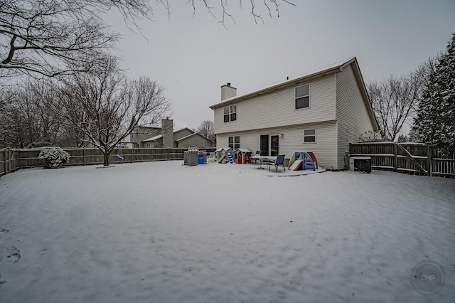 snow covered house featuring central air condition unit