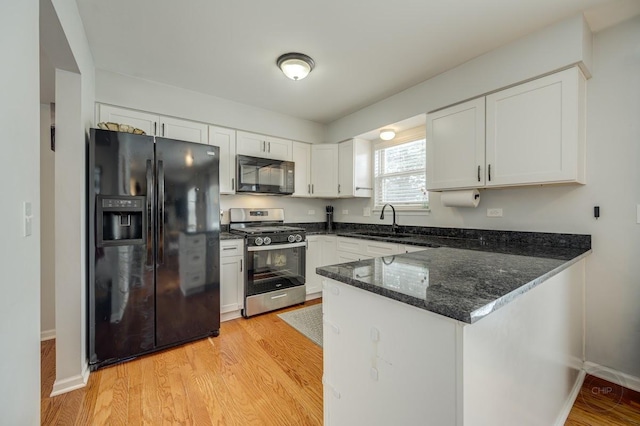 kitchen with kitchen peninsula, white cabinetry, sink, and black appliances