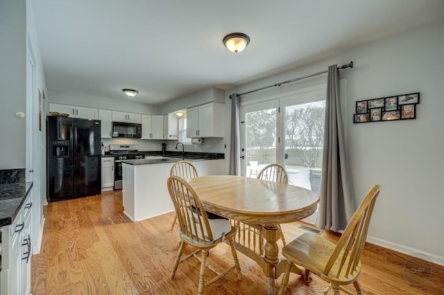 dining area featuring light wood-type flooring and sink