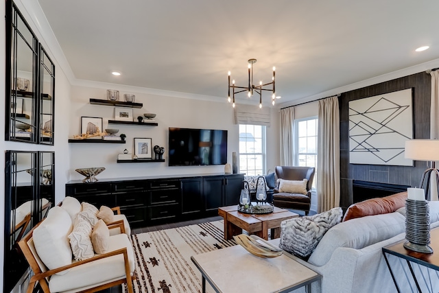 living room with a fireplace, an inviting chandelier, and ornamental molding