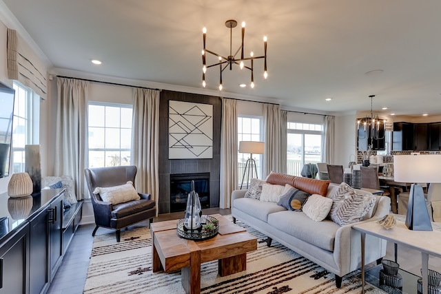 living room featuring light hardwood / wood-style floors, a notable chandelier, and a tiled fireplace