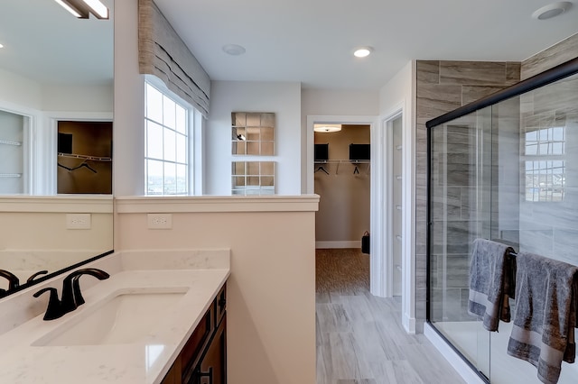 bathroom featuring hardwood / wood-style floors, vanity, and a shower with shower door