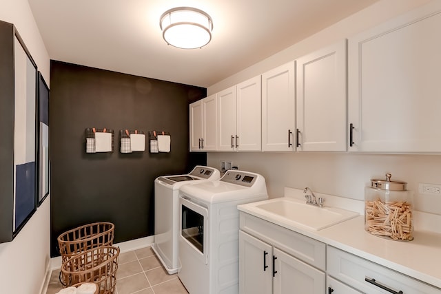 clothes washing area featuring cabinets, light tile patterned floors, sink, and washing machine and clothes dryer