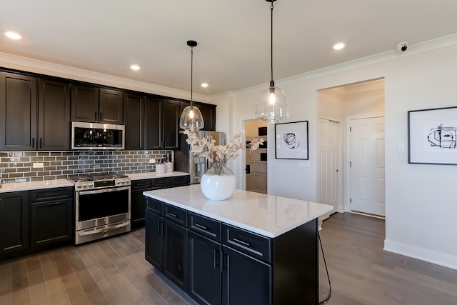 kitchen featuring appliances with stainless steel finishes, backsplash, dark wood-type flooring, pendant lighting, and a kitchen island