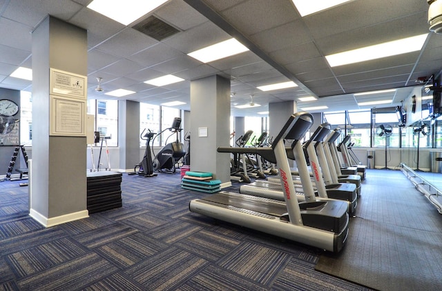 exercise room featuring dark colored carpet and a paneled ceiling