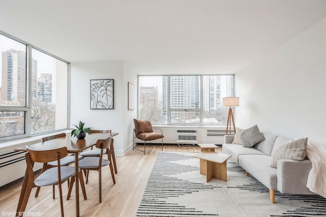 living room with plenty of natural light, light wood-type flooring, and a baseboard radiator