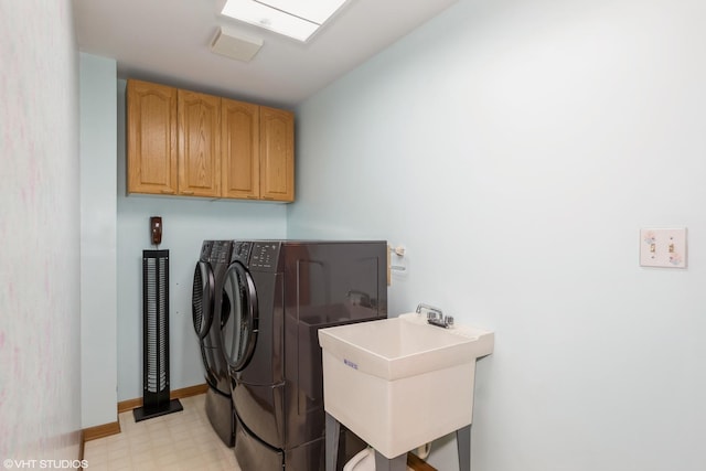 washroom featuring cabinets, independent washer and dryer, and sink