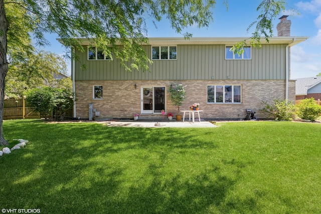 back of house with a lawn and a patio area