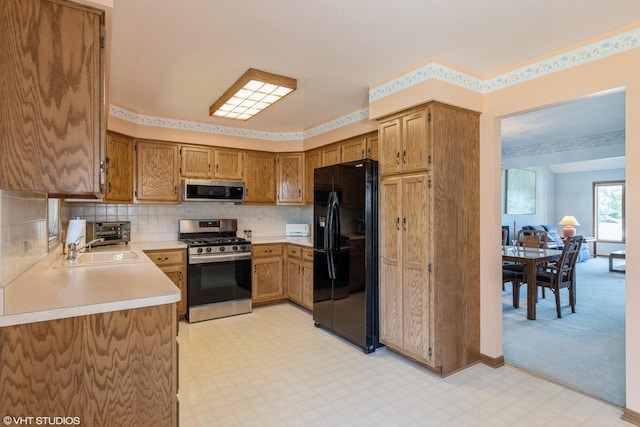 kitchen with tasteful backsplash, sink, light colored carpet, and stainless steel appliances