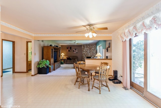 dining area featuring a fireplace, a wealth of natural light, and ceiling fan