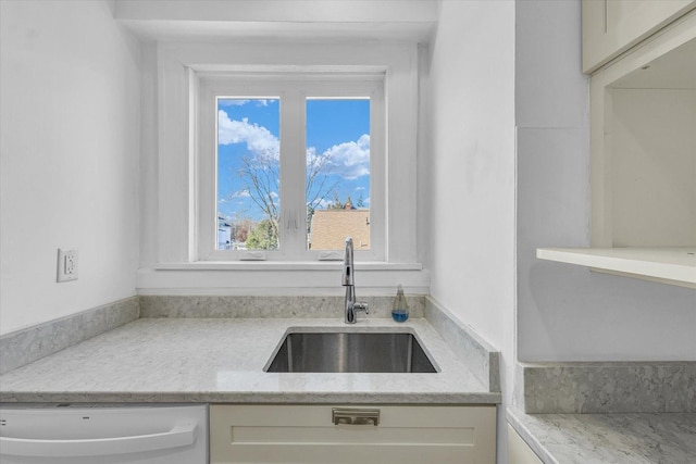 kitchen with dishwasher, sink, and light stone counters