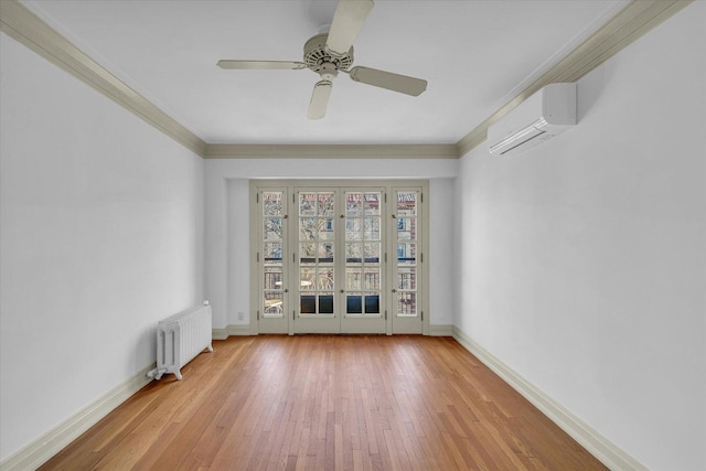 spare room featuring wood-type flooring, a wall mounted AC, ornamental molding, radiator heating unit, and ceiling fan