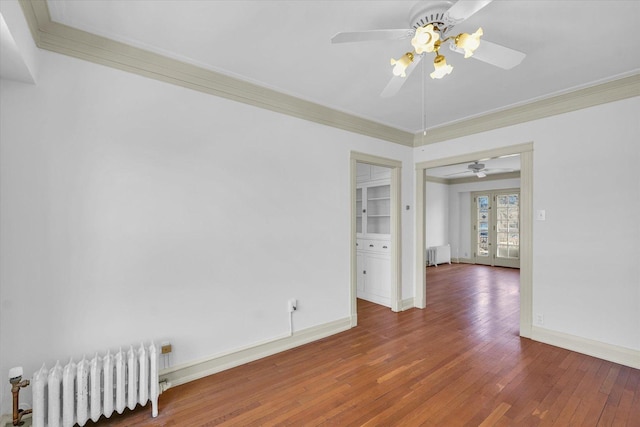 spare room with crown molding, radiator heating unit, dark hardwood / wood-style floors, and french doors