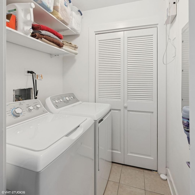 laundry room with washer and dryer and light tile patterned floors