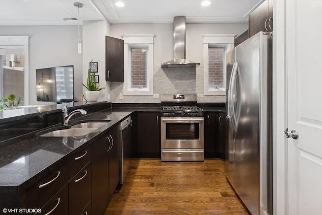 kitchen featuring sink, wall chimney exhaust hood, hanging light fixtures, dark wood-type flooring, and stainless steel appliances