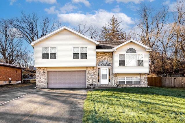 raised ranch featuring a front yard and a garage