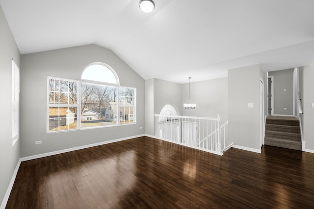 unfurnished room with a chandelier, dark wood-type flooring, and vaulted ceiling