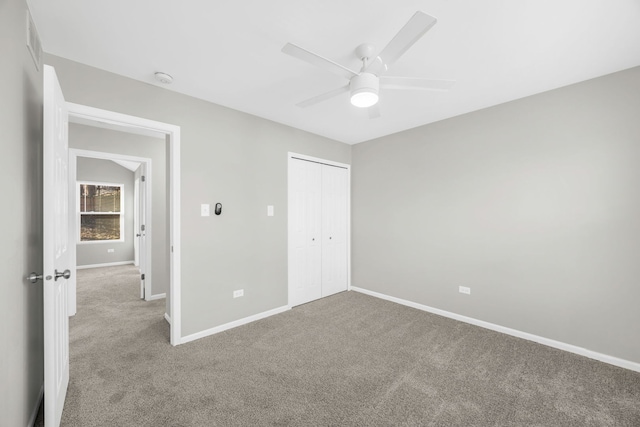 unfurnished bedroom with ceiling fan, a closet, and light carpet