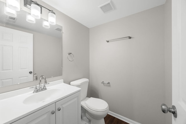 bathroom with vanity, toilet, and wood-type flooring