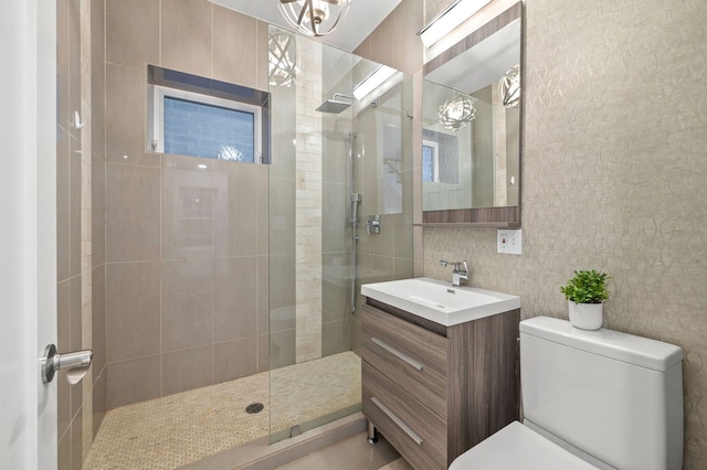 bathroom featuring tiled shower, toilet, and vanity