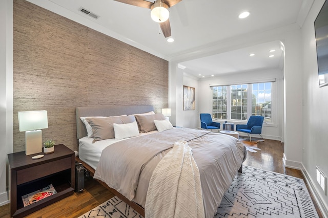 bedroom with ceiling fan, dark wood-type flooring, and crown molding