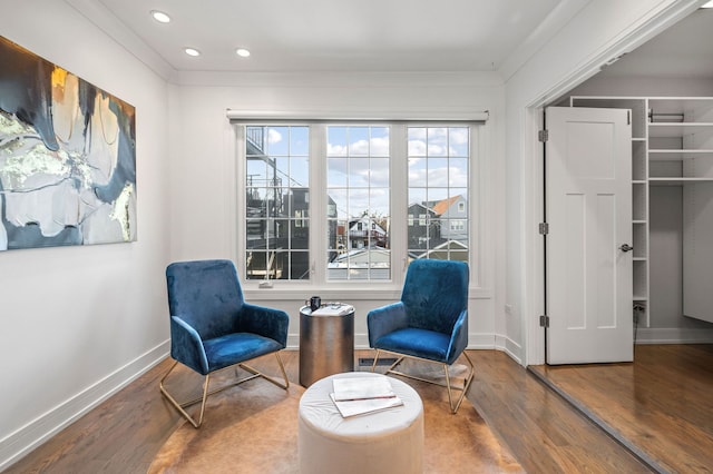 living area featuring hardwood / wood-style floors and ornamental molding