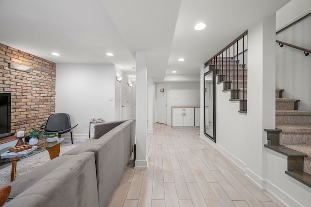 living room with light wood-type flooring and brick wall