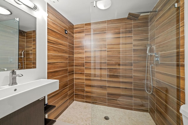 bathroom with tiled shower, vanity, and toilet