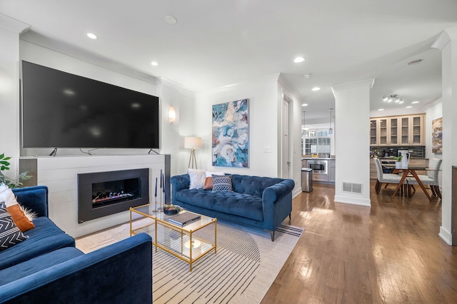 living room with hardwood / wood-style flooring and crown molding