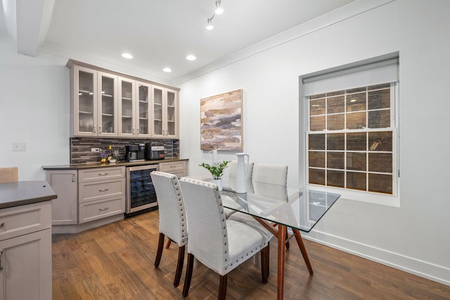 dining space with indoor bar, light hardwood / wood-style flooring, beverage cooler, and crown molding