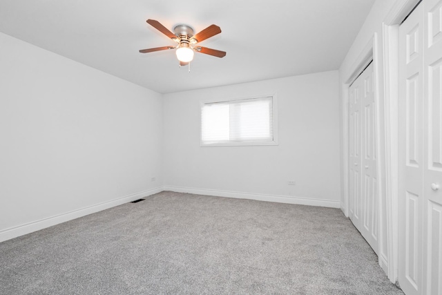 unfurnished bedroom with light carpet, two closets, and ceiling fan