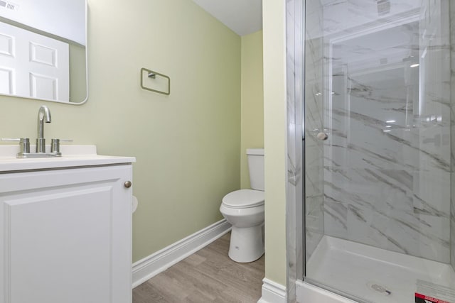 bathroom featuring an enclosed shower, vanity, toilet, and wood-type flooring