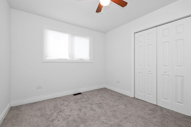 unfurnished bedroom featuring light carpet, a closet, and ceiling fan