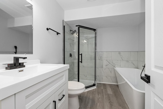 full bathroom with hardwood / wood-style floors, vanity, shower with separate bathtub, and toilet