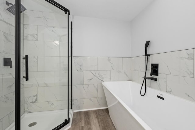 bathroom with hardwood / wood-style floors and independent shower and bath