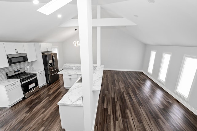 kitchen featuring white cabinetry, lofted ceiling with skylight, and stainless steel appliances