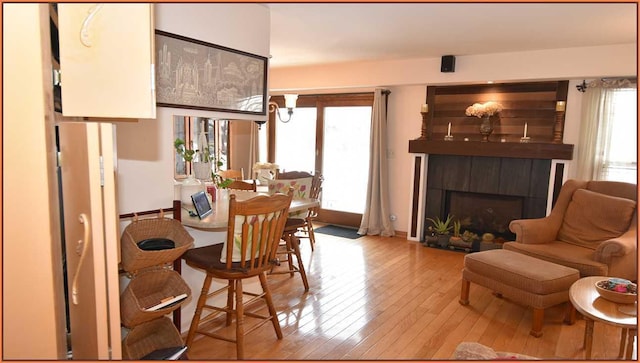 dining area featuring a wealth of natural light, a fireplace, and light wood-type flooring