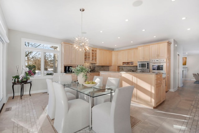 tiled dining area with an inviting chandelier and sink