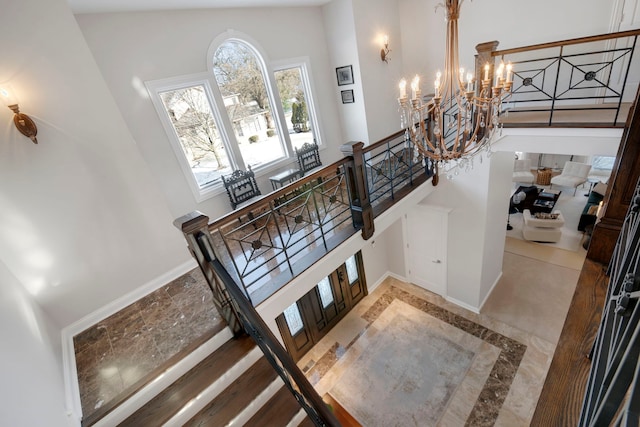 staircase with a notable chandelier and a high ceiling