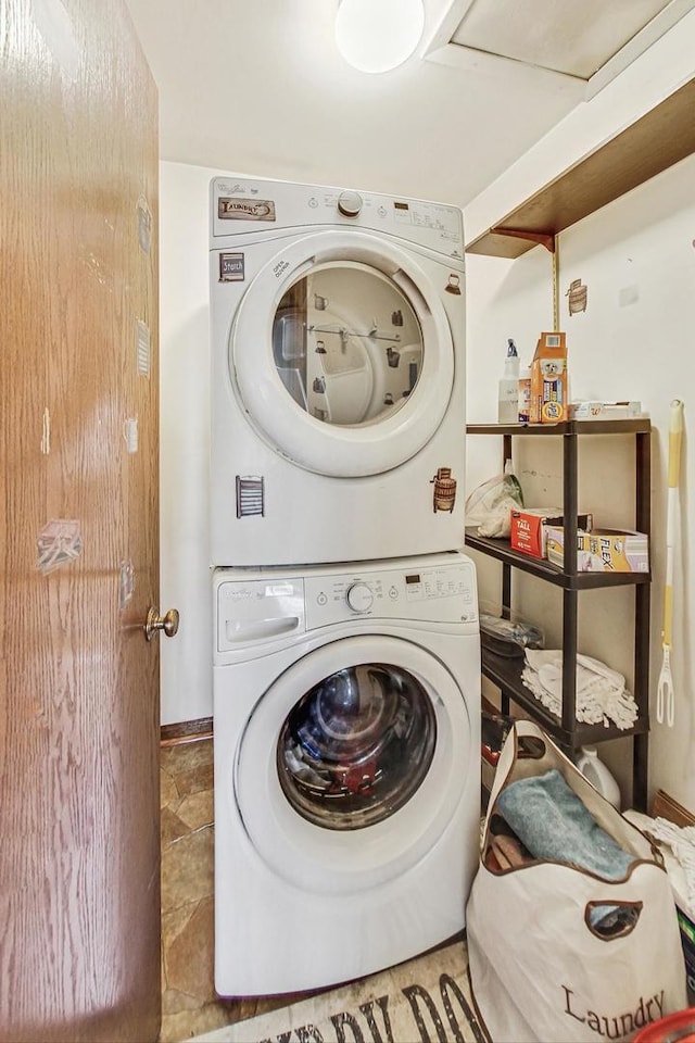 washroom featuring stacked washer and clothes dryer