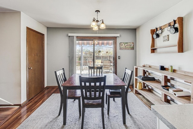 dining space featuring dark hardwood / wood-style flooring and a chandelier