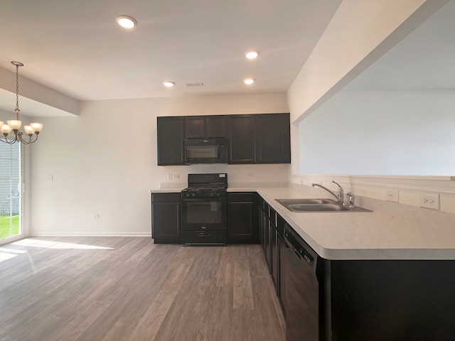 kitchen with black appliances, pendant lighting, kitchen peninsula, and sink