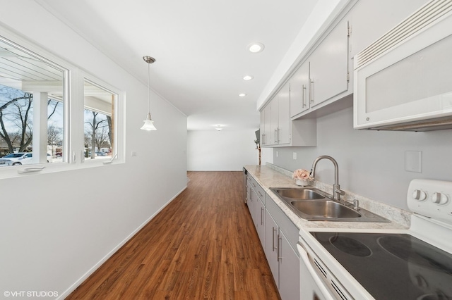 kitchen with dark hardwood / wood-style floors, pendant lighting, sink, white appliances, and white cabinets