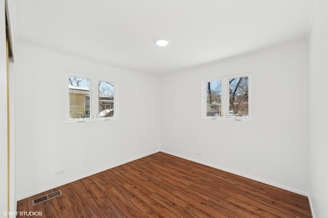 spare room featuring hardwood / wood-style flooring, a wealth of natural light, and ornamental molding