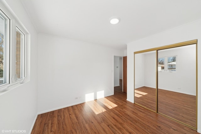 unfurnished bedroom featuring a closet and hardwood / wood-style flooring