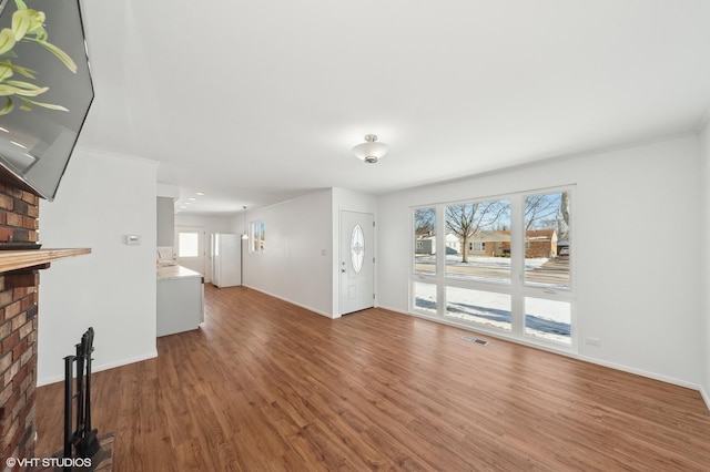 unfurnished living room featuring a fireplace, a wealth of natural light, and hardwood / wood-style flooring