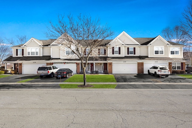 multi unit property featuring a garage and a front yard