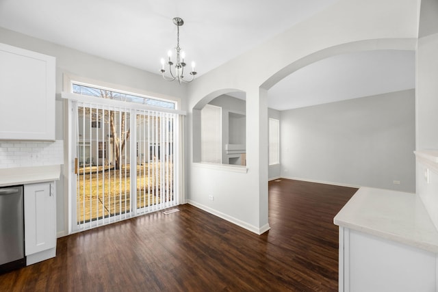 unfurnished dining area with an inviting chandelier and dark wood-type flooring